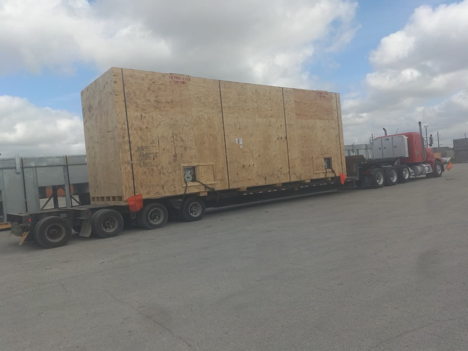 Crate staged on a spread-axle flatbed, ready for the road